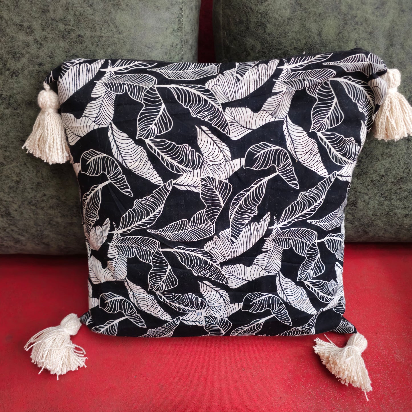 Black cotton cushion cover with banana leaf print and tassels