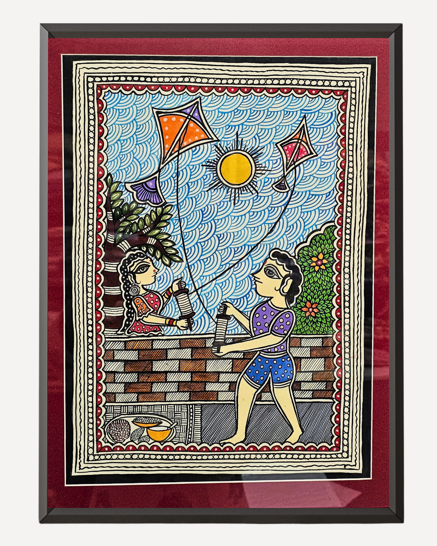 Framed artwork of two people flying kites with a colorful border.