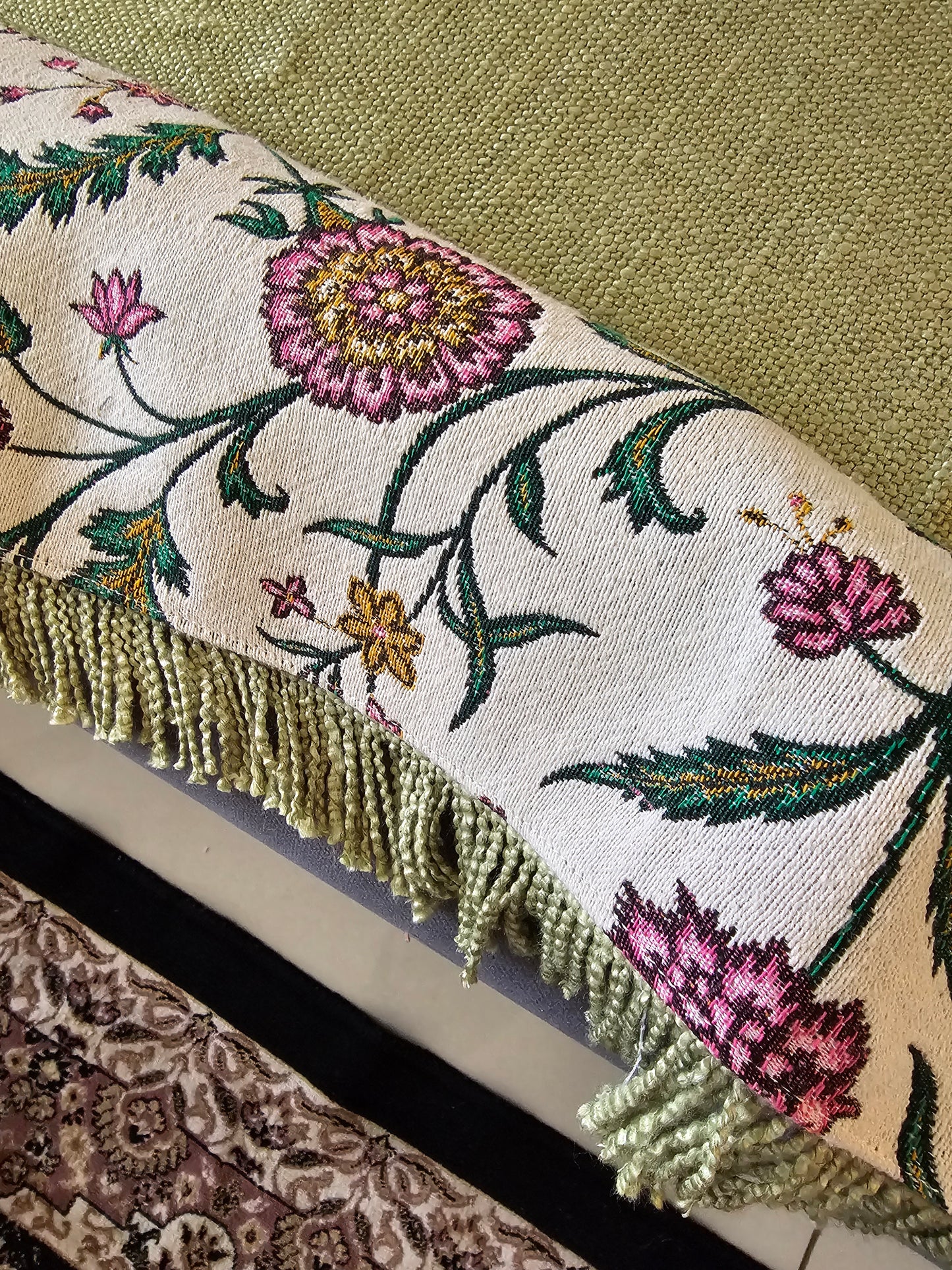 Close-up of an embroidered fabric with floral patterns on a textured surface.