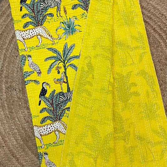 Yellow fabric with animal and plant pattern on a textured surface