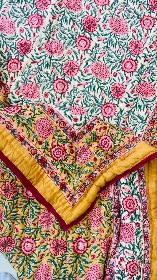 Floral patterned fabric with pink flowers and green leaves on a yellow background