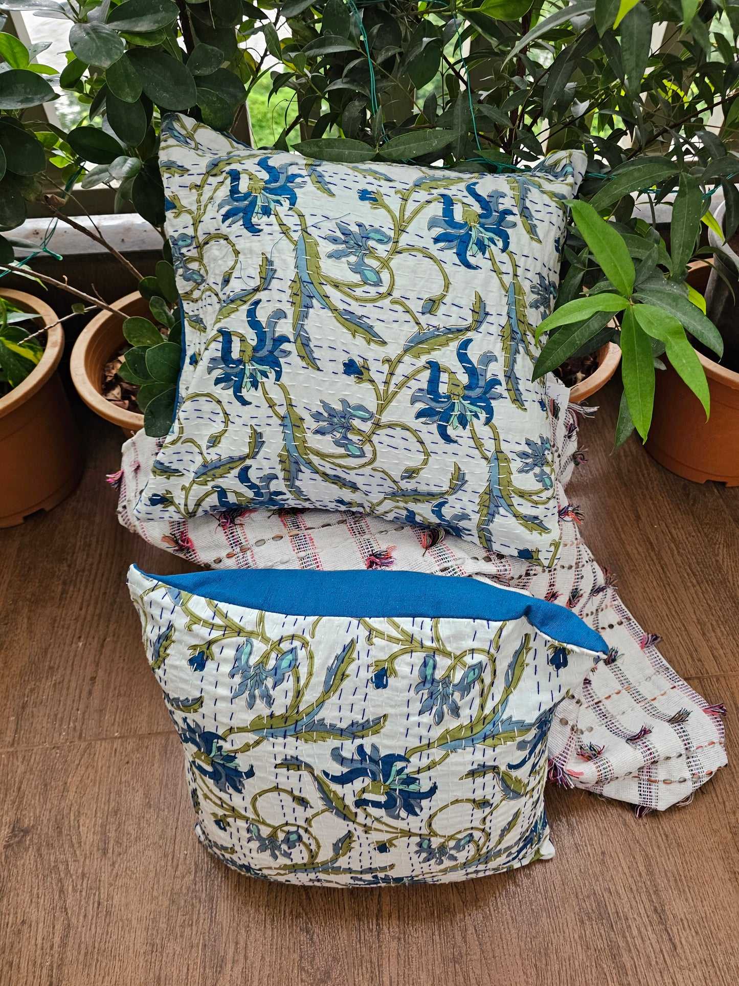 Decorative pillows with floral patterns on a wooden surface