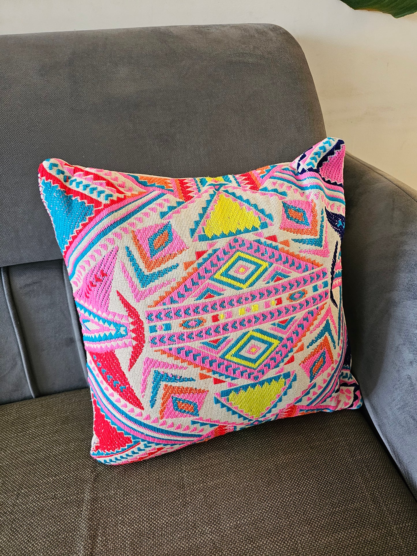 Colorful patterned pillow on a gray couch