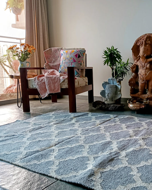 Living room with patterned rug, chairs, and decorative items.