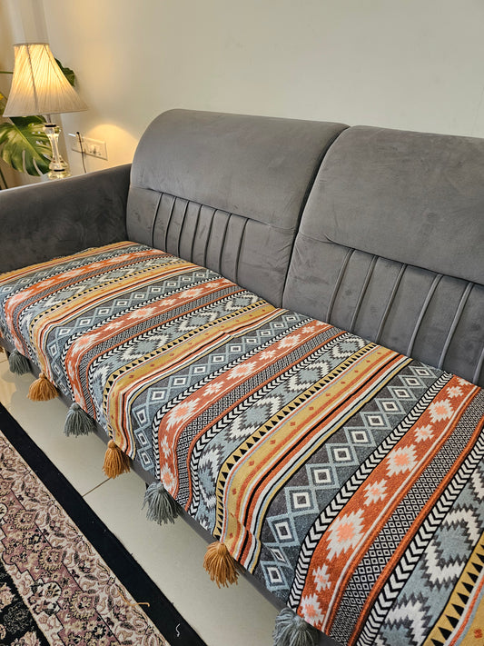 Gray suit with a patterned multicolored scarf draped over it on a neutral background