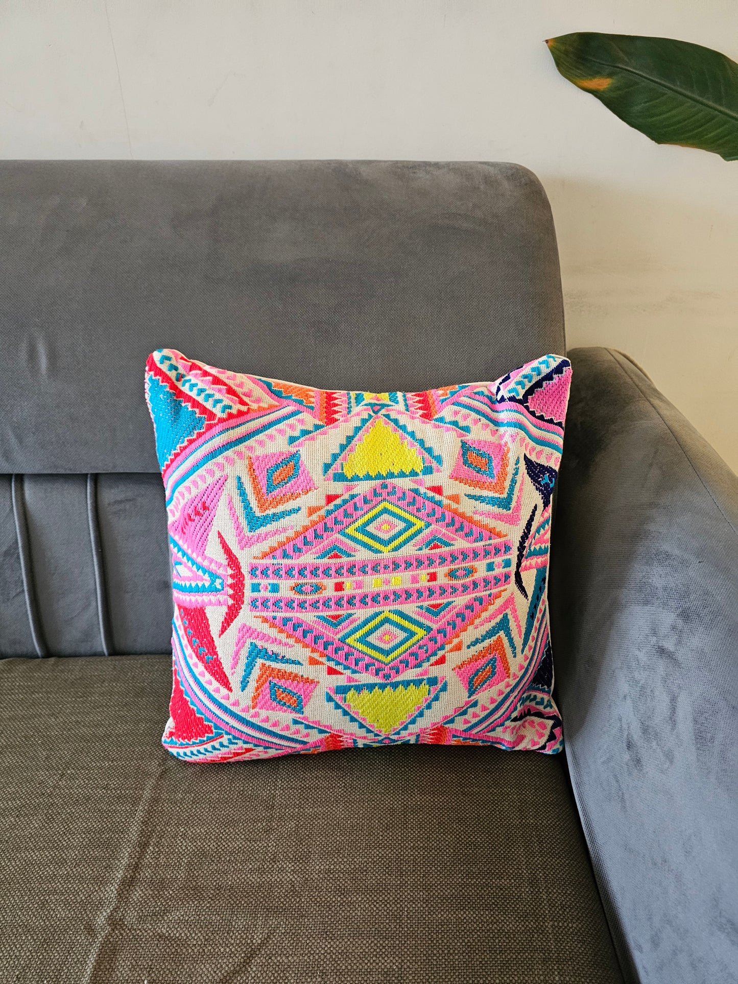 Colorful patterned pillow on a gray sofa