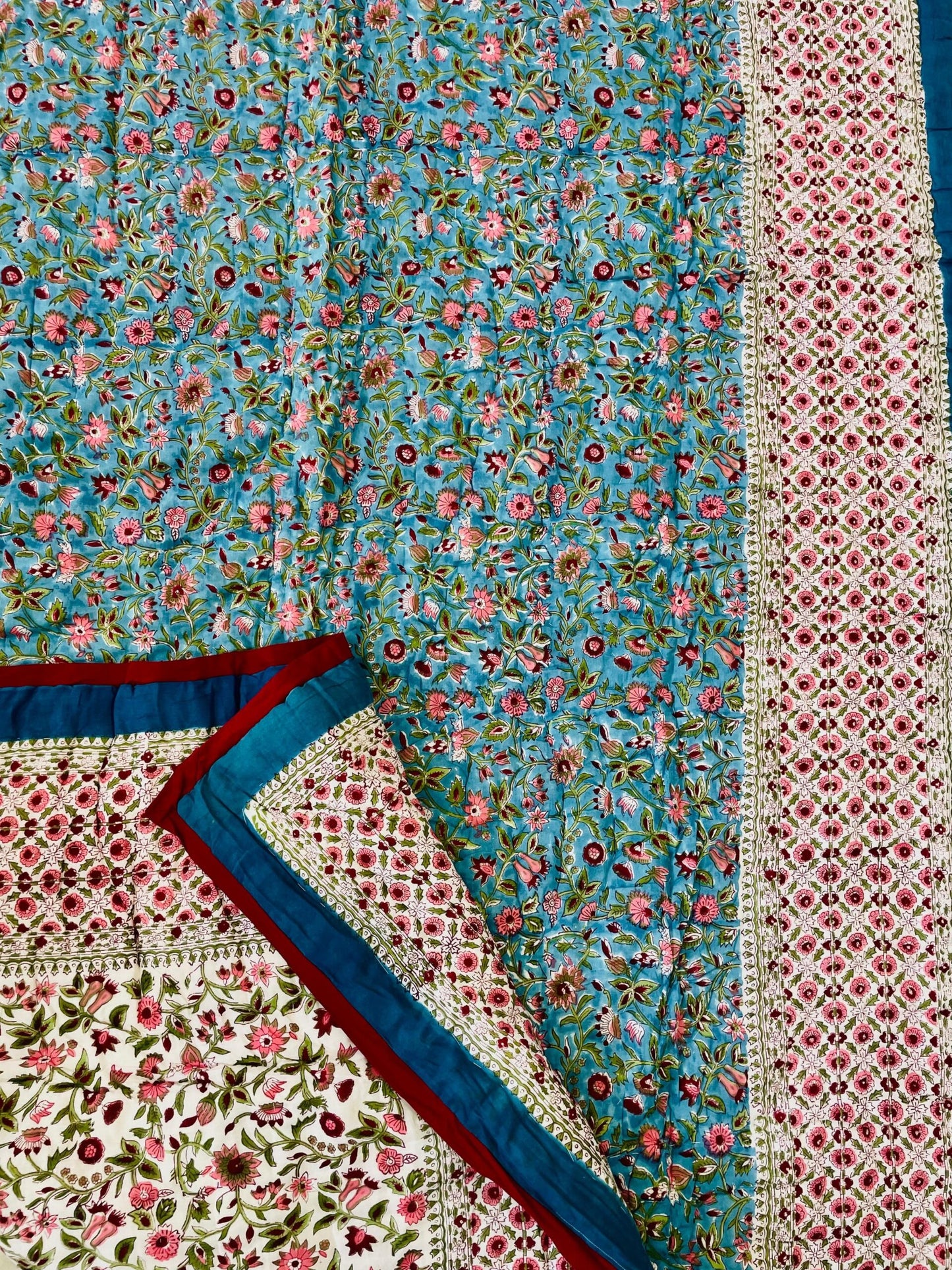 Multicolored floral and geometric patterned fabric with a focus on blue and pink tones.