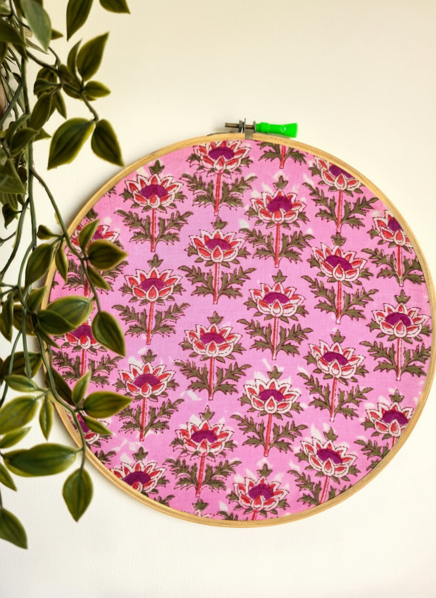 Embroidery hoop with pink floral pattern on a white background