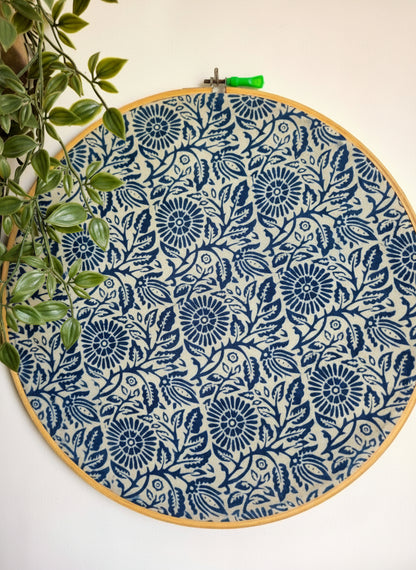 Embroidery hoop with blue floral pattern on a white background