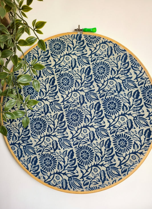 Embroidery hoop with blue floral pattern on a white background