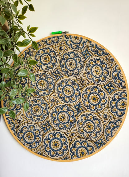 Decorative round mat with blue and gold pattern on a white wall