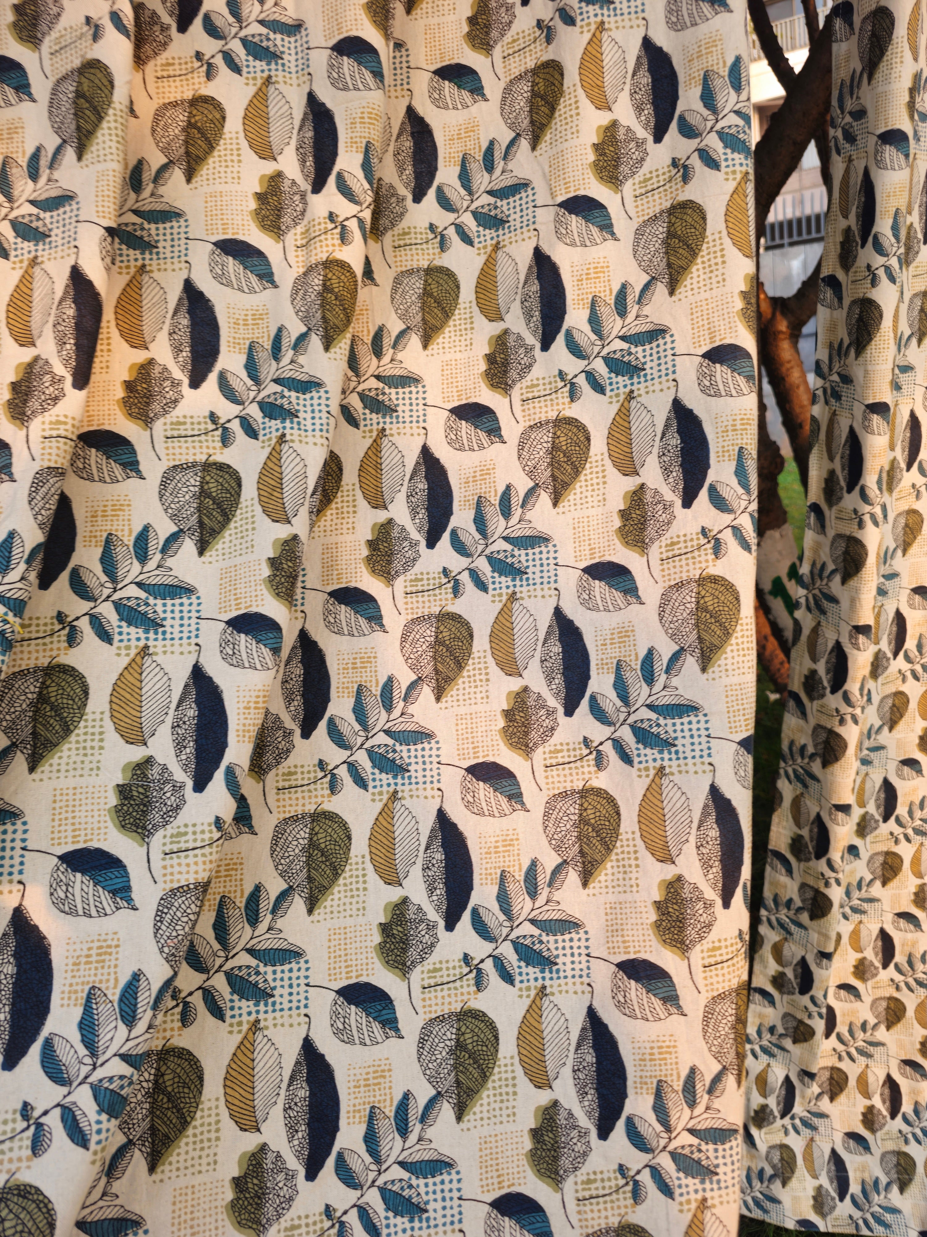 Close-up of fabric with leaf pattern in beige, brown, and blue tones.