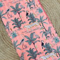 Fabric with a pink background featuring animal and plant patterns