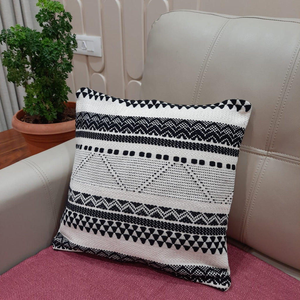 Artisanal rust and monochrome cushion set styled in a boho living room with plants and a woven rug.