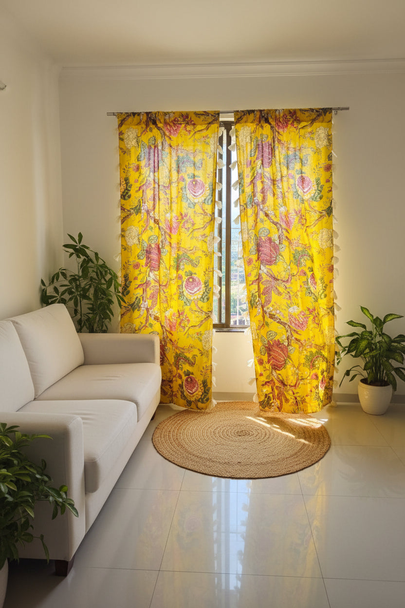 Living room with a white sofa, yellow floral curtains, and potted plants.
