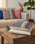 Decorative pillows on a beige sofa and wooden coffee table in a living room.