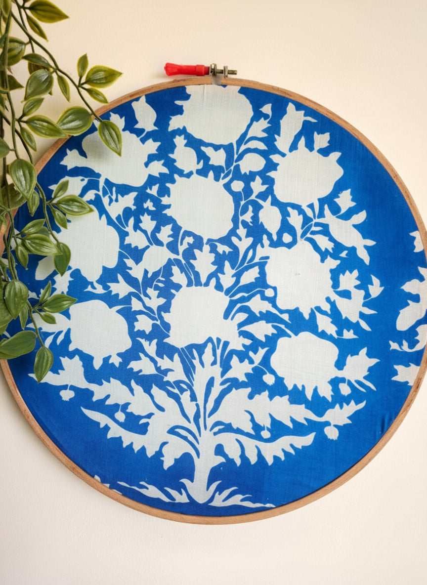 Embroidery hoop with blue and white floral pattern on a white background