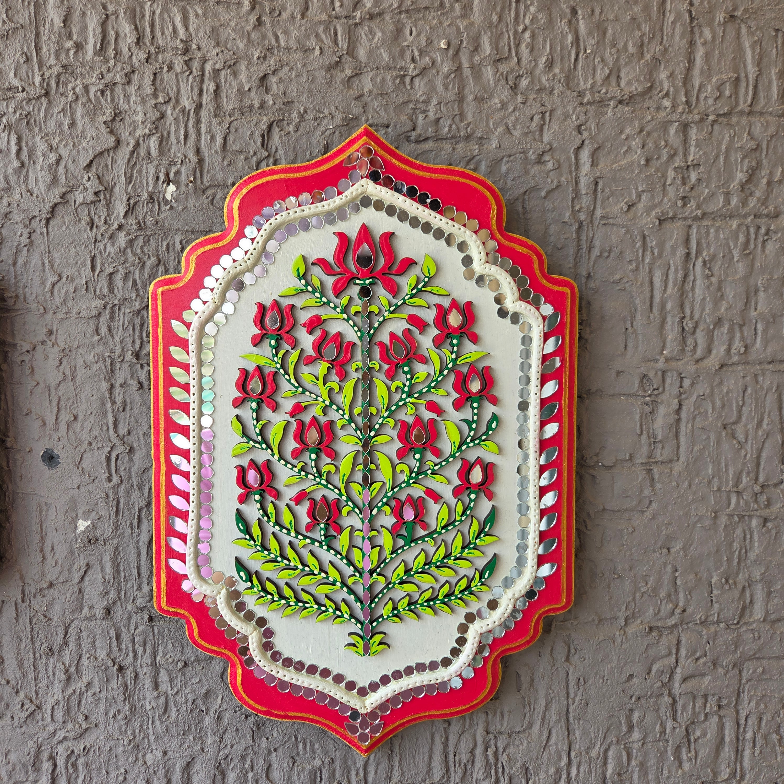 Decorative wall art with floral design on a textured wall