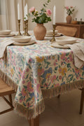 Floral tablecloth on a dining table with candles and flowers.