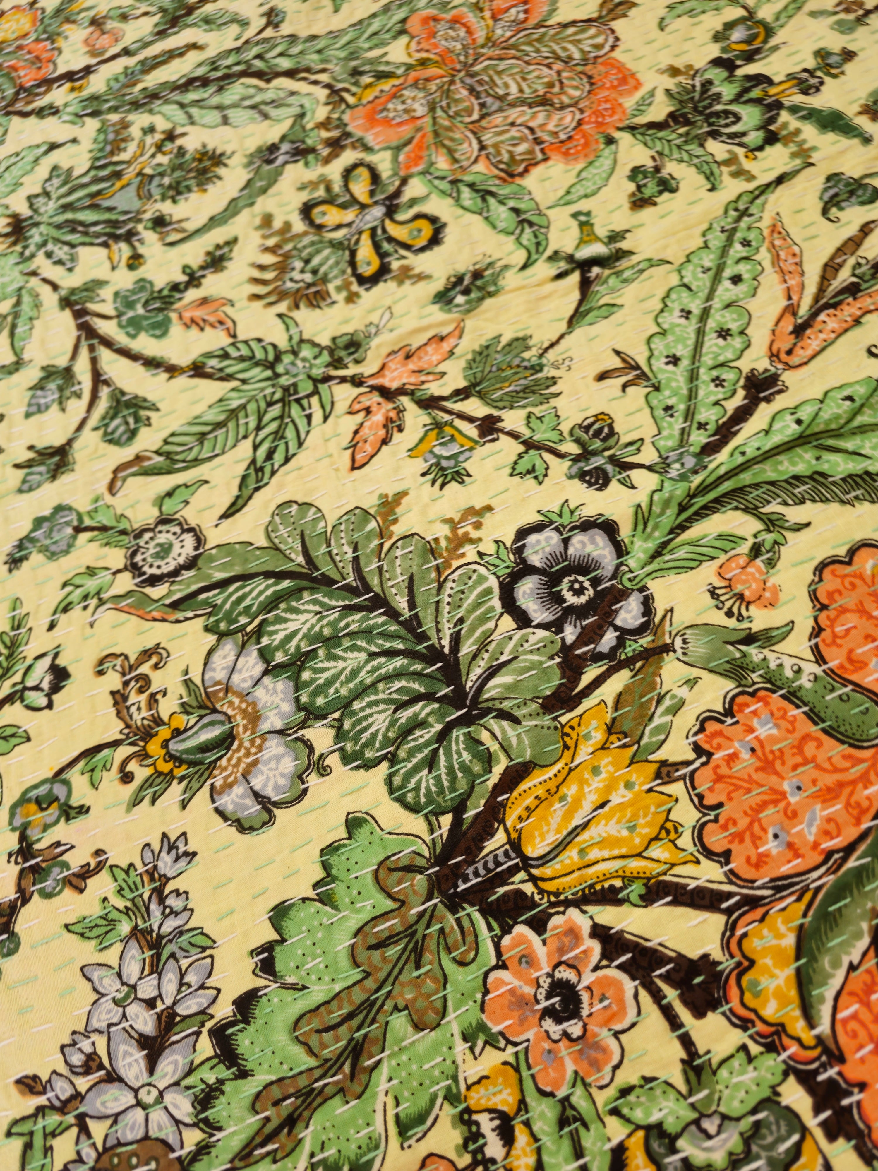 Close-up of a floral and leaf pattern on fabric with a beige background.
