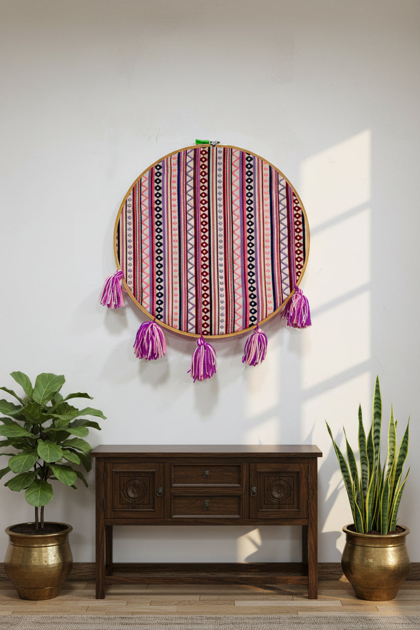 Decorative hoop with colorful striped pattern and purple tassels on a white background