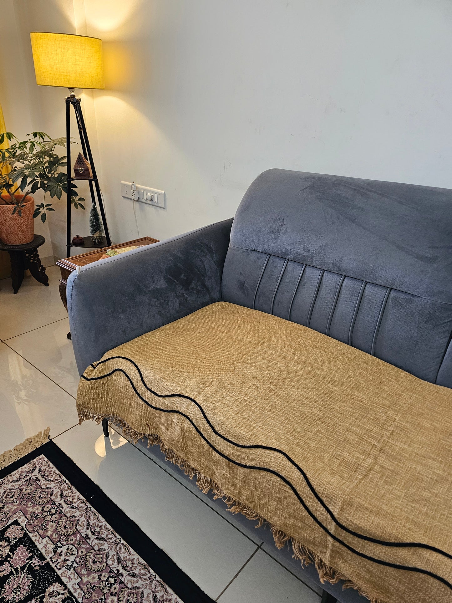 Gray suit jacket draped over a chair with a patterned rug on the floor.