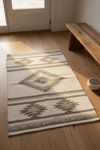 Patterned rug on a wooden floor with a wooden bench and door in the background