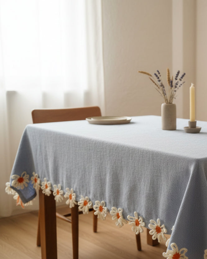 Crocheted flowers with orange centers on a textured fabric background