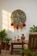 Embroidered hoop with floral pattern and colorful tassels on a white background