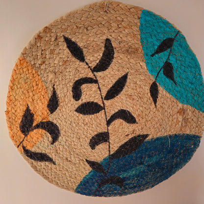 Decorative round mat with leaf design on a wooden table