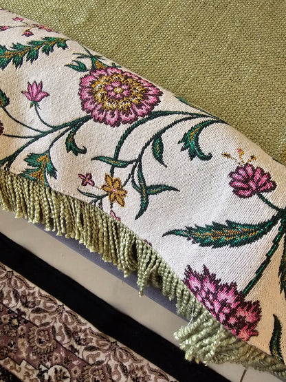 Close-up of an embroidered fabric with floral patterns on a textured surface.