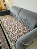 Vasaca handwoven jacquard cotton sofa cover featuring an arch and palm tree pattern with tassels on a grey sofa.