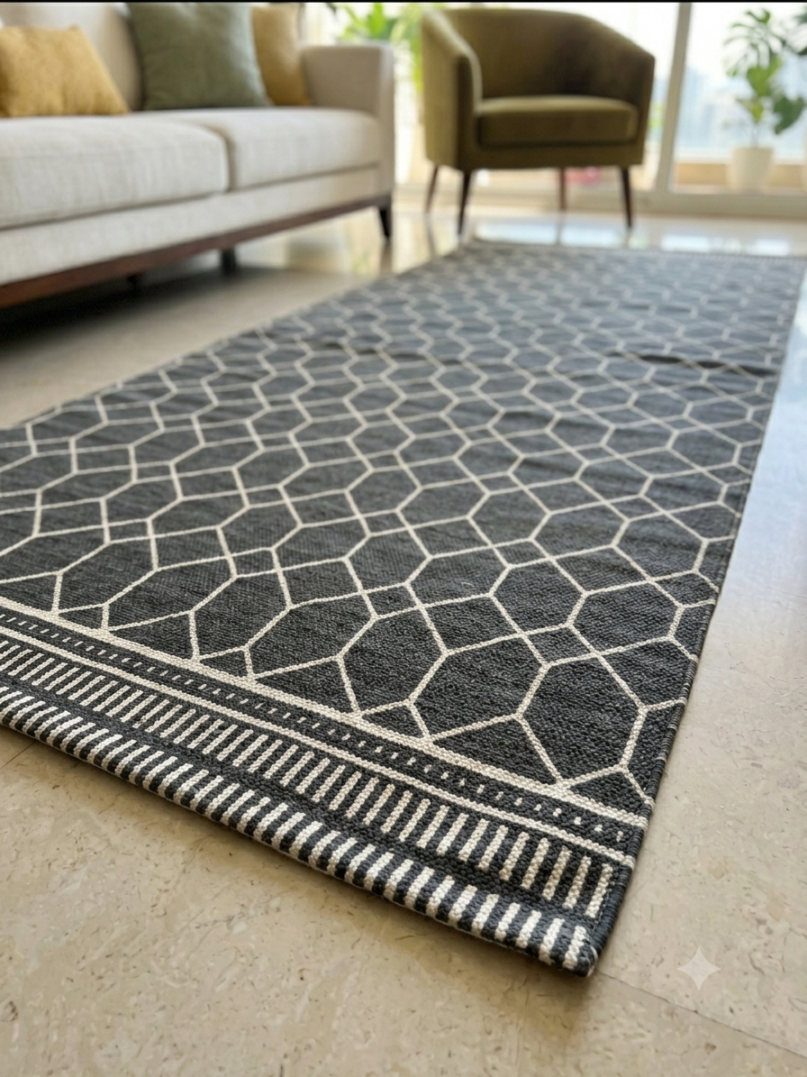 Vasaca charcoal dark grey handwoven cotton flatweave runner rug with off-white geometric lattice pattern, striped end-borders, and tassels.