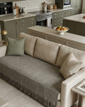 Vasaca dark grey thick handwoven cotton seat-only sofa runner with slubbed texture and fringed edge, fitted onto the seating cushions of a three-seater sofa.