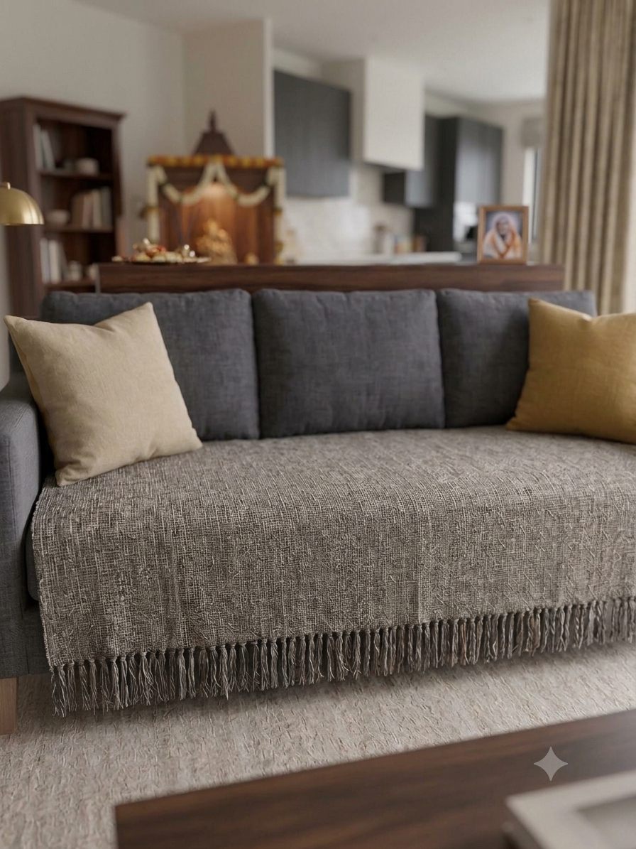 Vasaca dark grey thick handwoven cotton seat-only sofa runner with slubbed texture and fringed edge, fitted onto the seating cushions of a three-seater sofa.