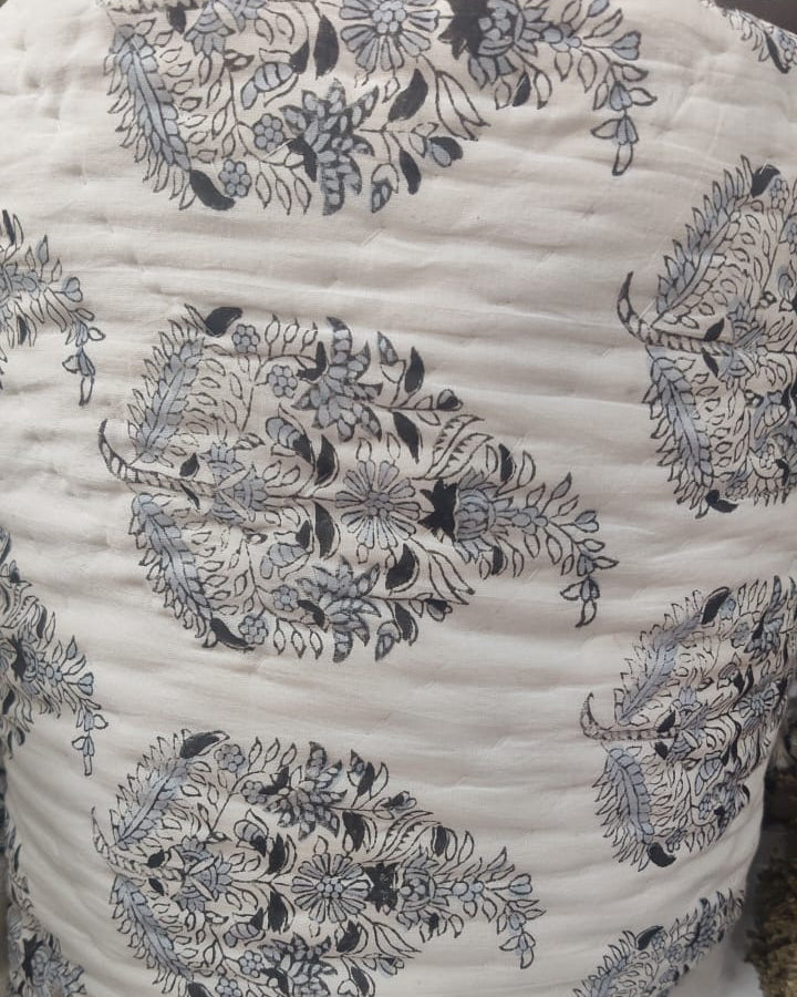 Close-up view of a Vasaca handblock printed cotton single bed razai featuring traditional charcoal floral motifs on a cream fabric with quilted texture.