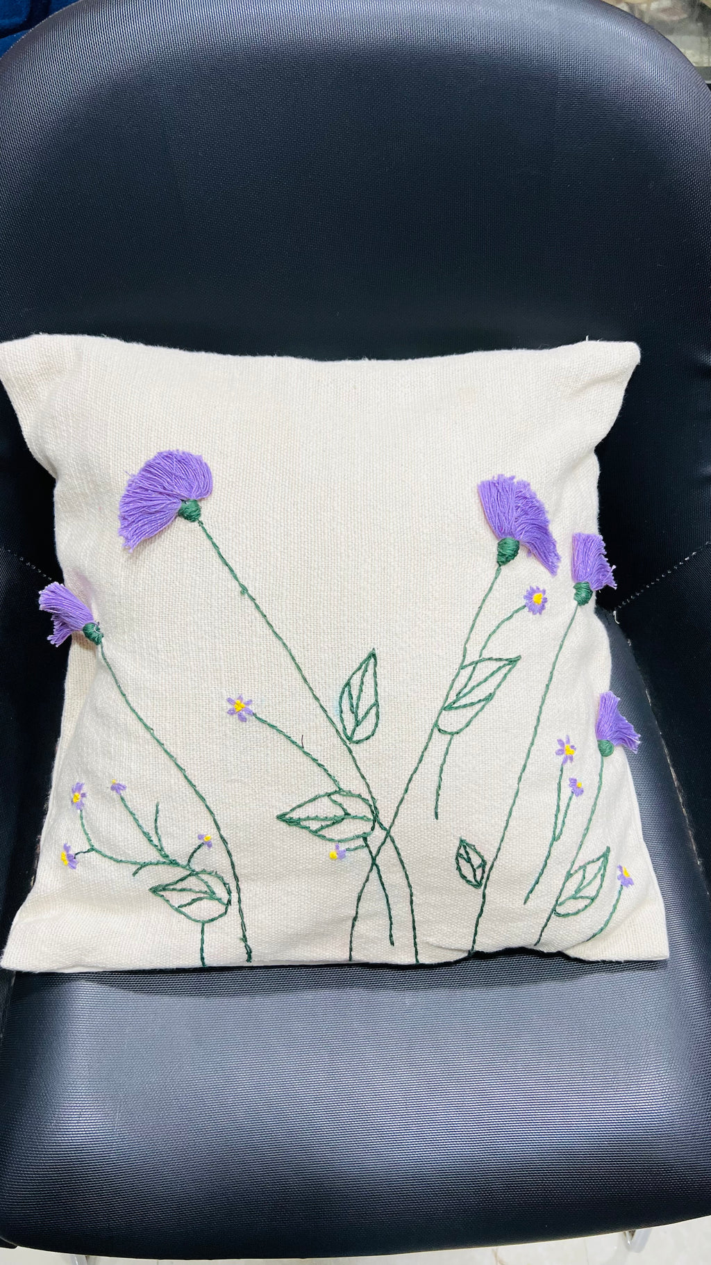 Vasaca jute-cotton handcrafted floral embroidered throw pillow cover featuring hand-stitched green stems and textured purple floral blooms on a natural off-white jute-cotton base