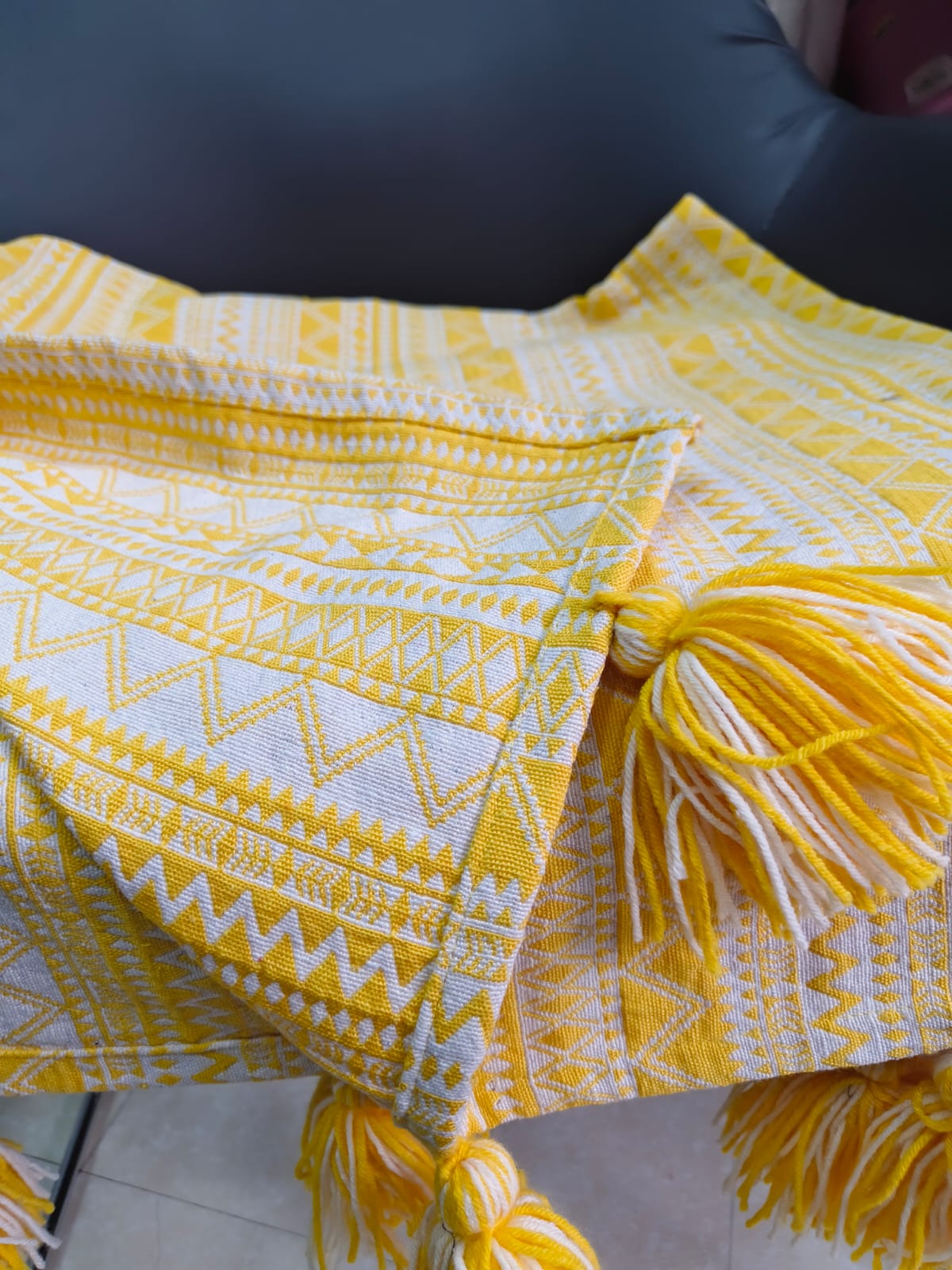 Vasaca yellow and white abstract zig-zag jacquard cotton seat-only sofa runner featuring intricate geometric stripes and chunky corner tassels, tailored for a three-seater sofa.
