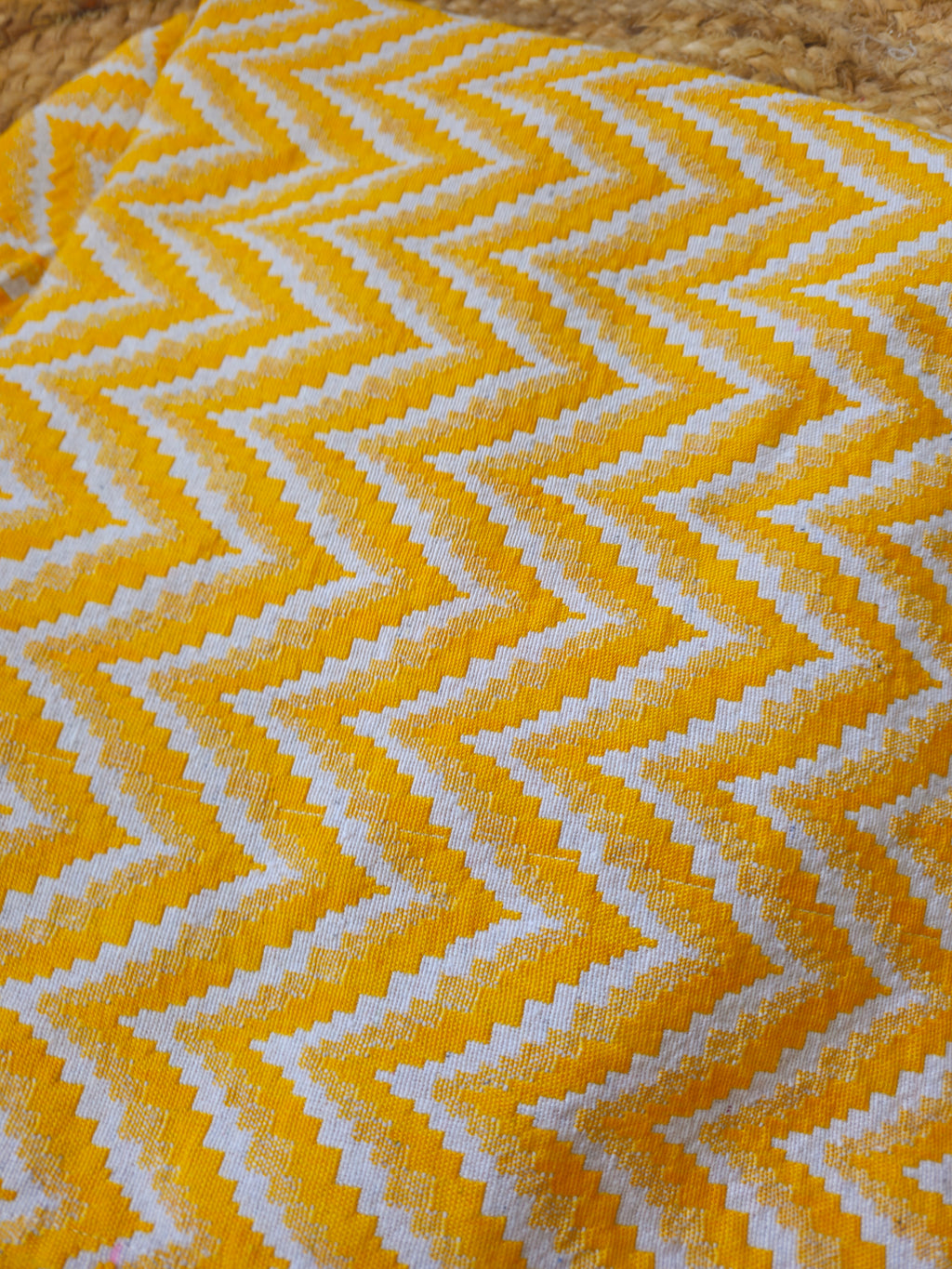 Yellow and white zigzag patterned fabric on a wooden surface