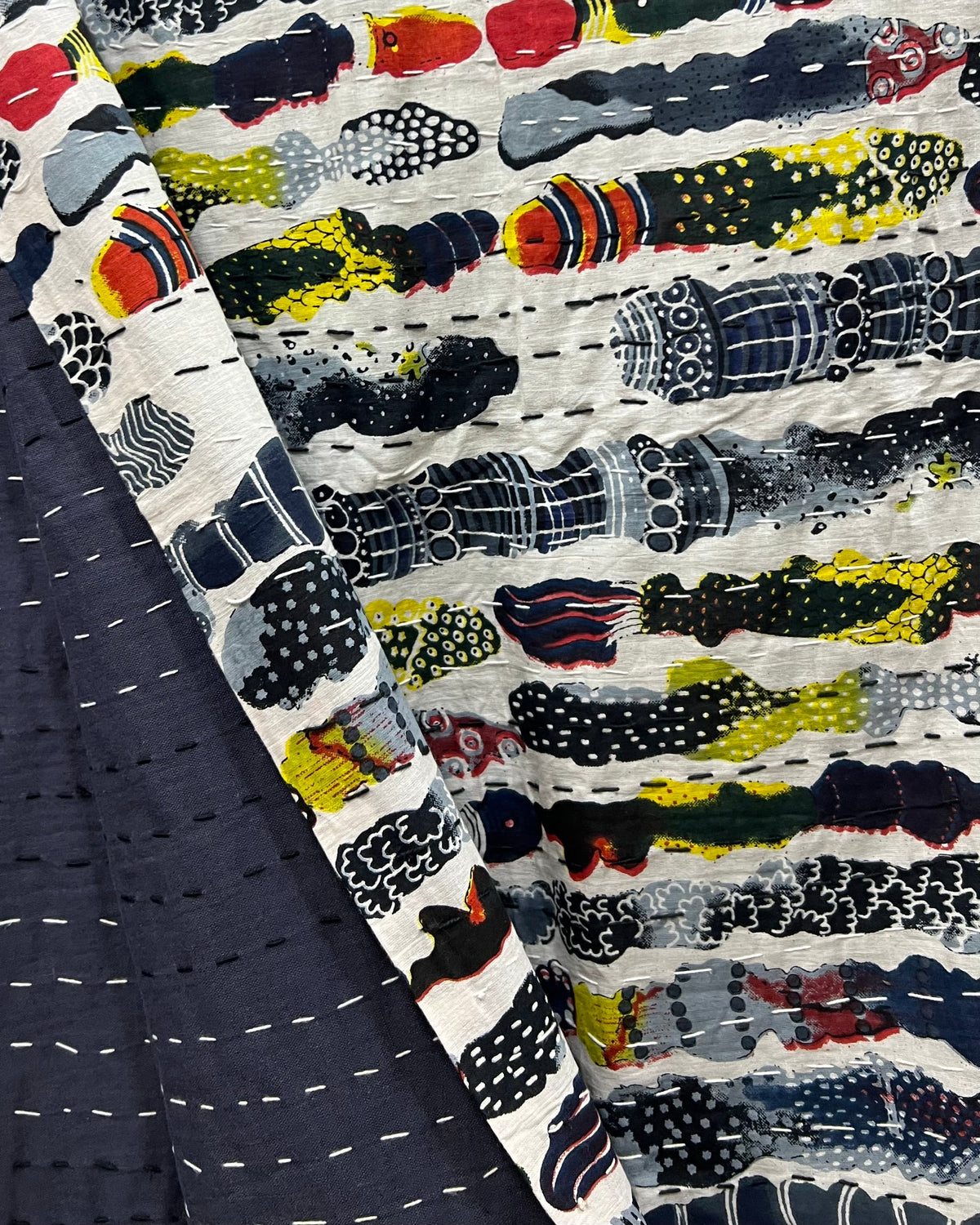 Abstract print handloom slub cotton king size bed cover featuring an artistic textured weave and handcrafted fringe tassels.