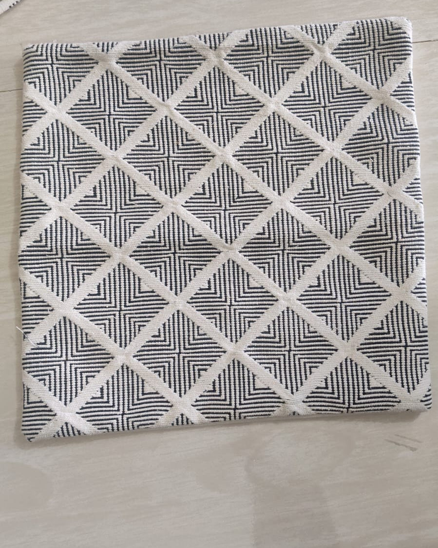 Square off-white cotton cushion cover with a charcoal black geometric diamond line pattern displayed flat.