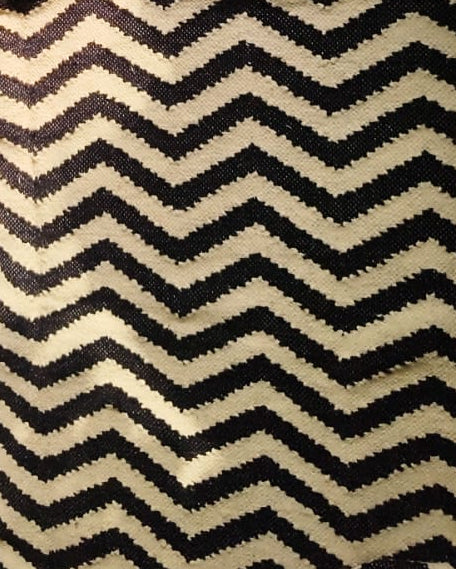 Black and white chevron geometric flatweave cotton area rug styled in a modern bohemian living room with fringe details.