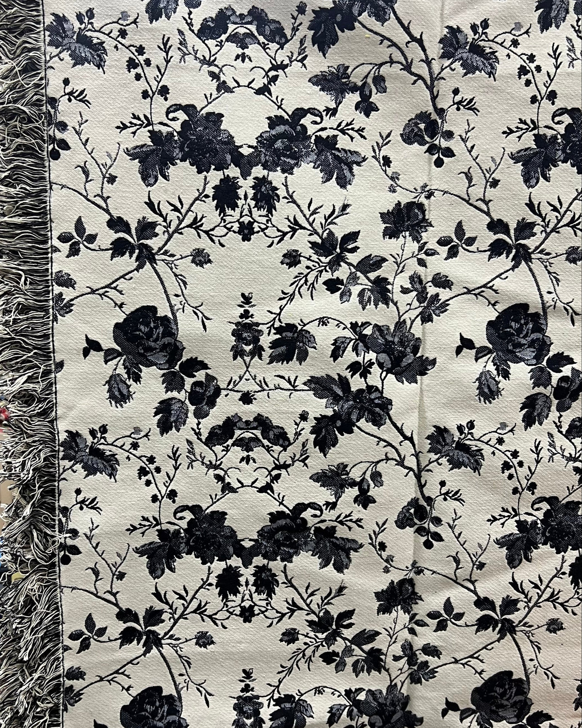 Black and white floral cotton jacquard table cover featuring a reversible monochrome woven pattern and decorative fringe tassels.