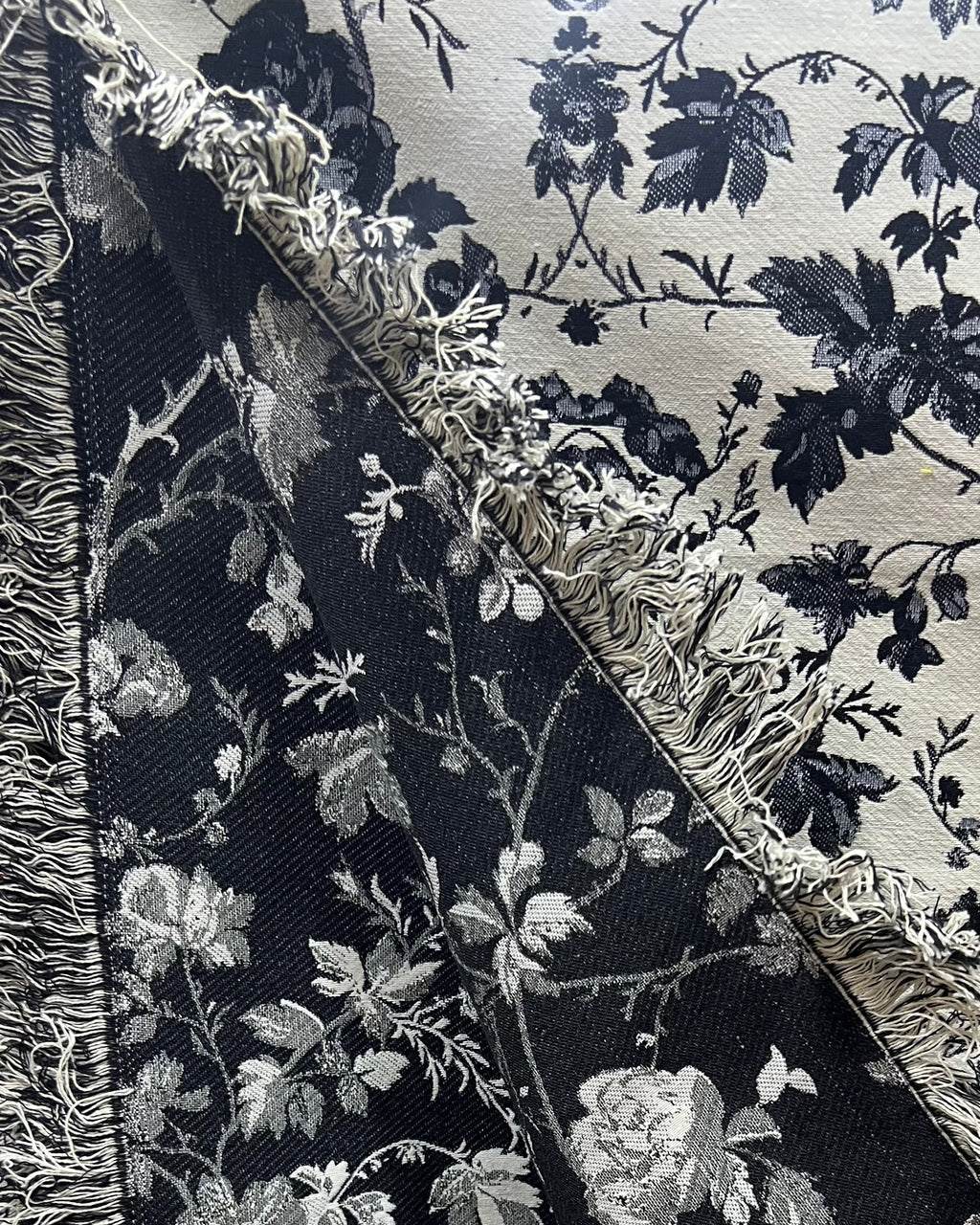 Black and white floral cotton jacquard table cover featuring a reversible monochrome woven pattern and decorative fringe tassels.