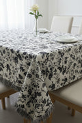Black and white floral cotton jacquard table cover featuring a reversible monochrome woven pattern and decorative fringe tassels