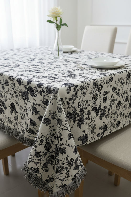Black and white floral cotton jacquard table cover featuring a reversible monochrome woven pattern and decorative fringe tassels