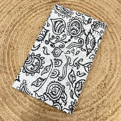Black paisley patterned fabric on a textured beige background