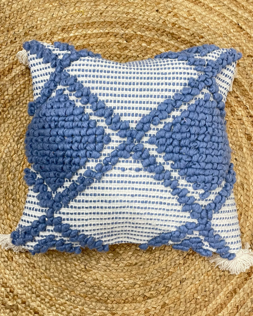 Set of 5 coastal boho-style cotton cushion covers, featuring two end pillows with blue tufted diamonds, two inner pillows with textured blue patterns, and a central white pillow with blue tufted lines and tassels, arranged neatly on a blue sofa in a bright living room.