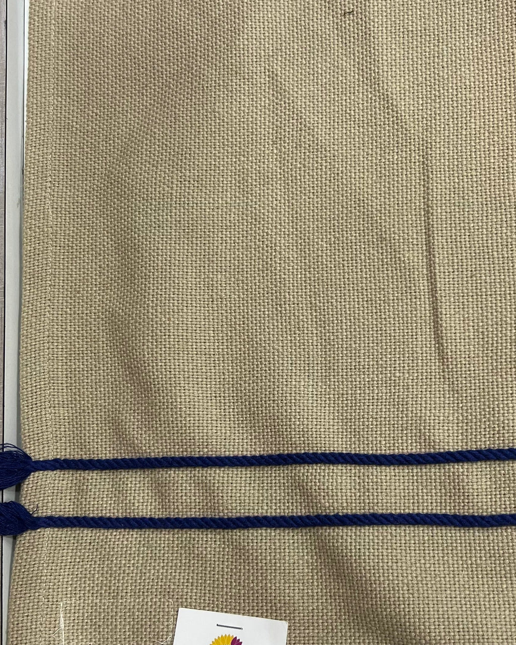 Natural textured burlap-style cotton placemat featuring navy blue horizontal stripes and side tassels.