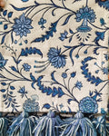 Blue and white floral Jacquard cotton dining table runner featuring an intricate botanical vine pattern and two-tone woolen hanging tassels, with Vasaca brand labels.